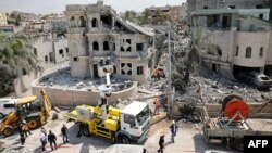 Спасательные команды расчищают завалы в районе поселения Тамра на севере Израиля после ночного ракетного обстрела со стороны Ирана, 15 июня 2025 года