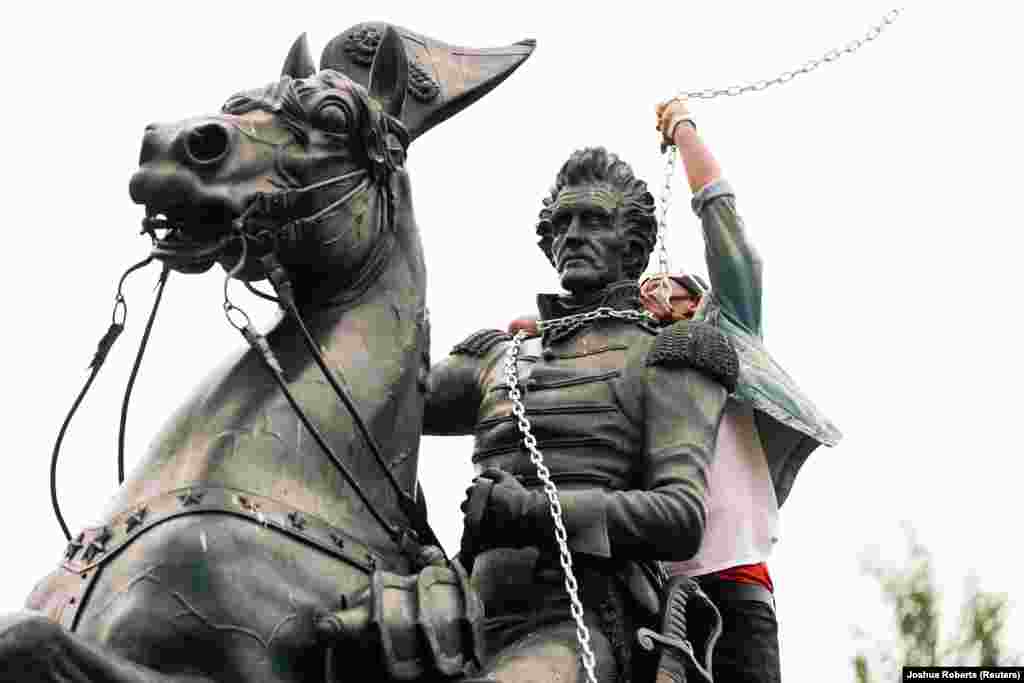 Протестувальник оповиває ланцюгами шию пам’ятника президентові США Ендрю Джексонові під час спроби демонстрантів скинути цей пам’ятник у центрі парку Лафаєт. Вашингтон, округ Колумбія, США