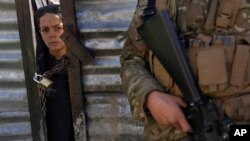 Afganistanski dječak gleda kroz zaključana vrata dok čeka red da primi hranu tokom distribucije humanitarne pomoći porodicama u potrebi u Kabulu.