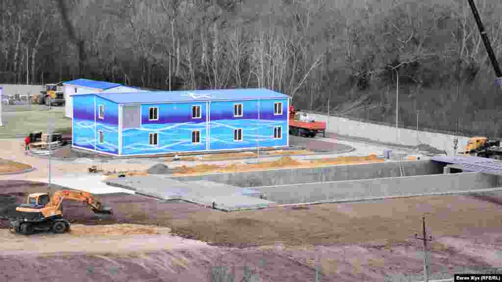 Двухэтажное здание – локальные очистные сооружения очистки промывных вод. На переднем плане – бетонный аккумулирующий резервуар промывных вод, которые будут приходить с очистных станций