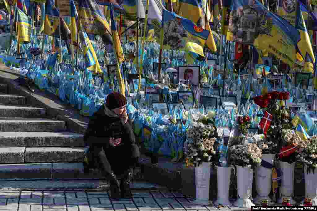 Вдень на майдан Незалежності у Києві містяни та гості міста прийшли до меморіалу з прапорців, які встановлюють рідні та друзі загиблих на війні. Люди несли квіти й запалювали лампадки   