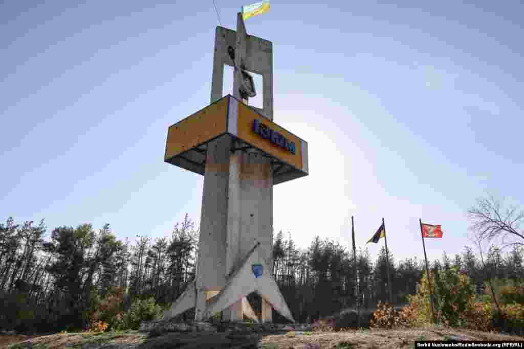 Стела міста Ізюму (вʼїзд з боку Харкова) поруч на землі лежить російський прапор. Охочі фотографуються на ньому та витирають об нього ноги, вересень 2022 року / Праворуч: жовтень 2024-го