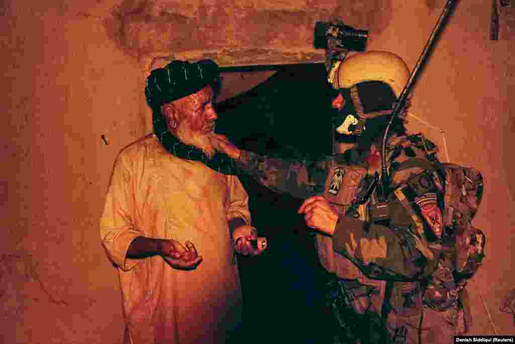 A special forces soldier speaks to a resident as others search his house during the anti-Taliban operation on July 12. 
