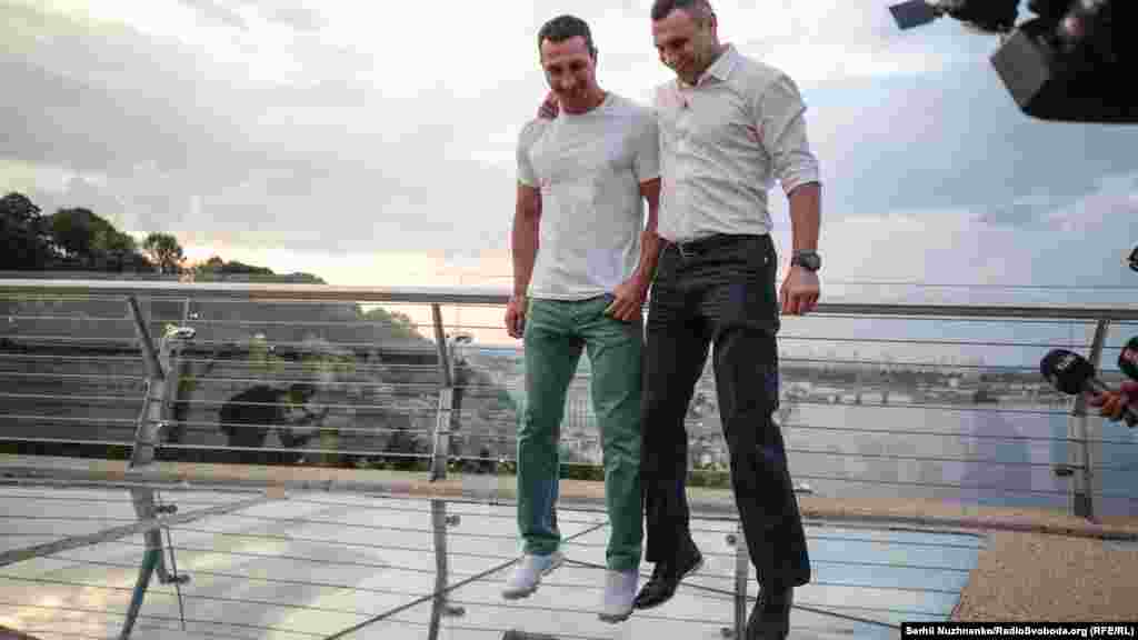 Володимир (ліворуч) та Віталій (праворуч) Клички стрибають на скляних конструкціях мосту. Вага Володимира Кличка 109 кілограмів, вага Віталія – 112 кілограмів. Брати продемонстрували міцність споруди своїми стрибками.