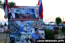 "Бывали дни веселые": плакат с изображениями Башара Асада и Владимира Путина в портовом городе Тартус, недалеко от российской военной базы. Фото 2022 года