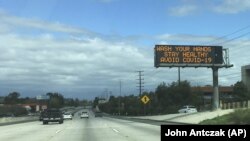 Напис над шосе у долині Сан-Фернандо в Лос-Анджелесі: «Мийте руки, будьте здорові, уникайте COVID-19», 15 березня 2020 року