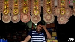 Традиционные свадебные гирлянды для молодоженов, свитые из денежных купюр. Магазин в Дели, 30 июля 2013 года