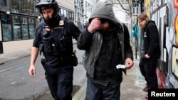 Смертність від наркотиків у США є серйозною проблемою, особливо через поширення синтетичних опіоїдів, таких як фентаніл. На фото поліцейський затримує чоловіка, який вживав фентаніл, штат Орегон, США, 2024 рік