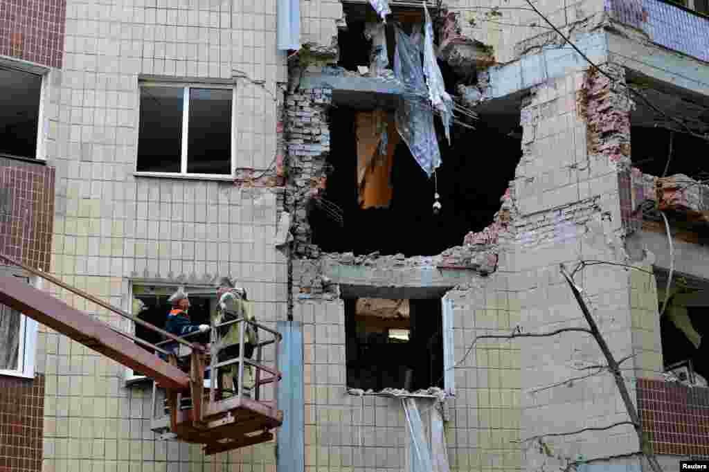 Рабочие убирают обломки в жилом доме, поврежденном в результате ночного обстрела, Донецк, контролируемый Россией, 16 августа 2025 года. REUTERS/Александр Ермоченко