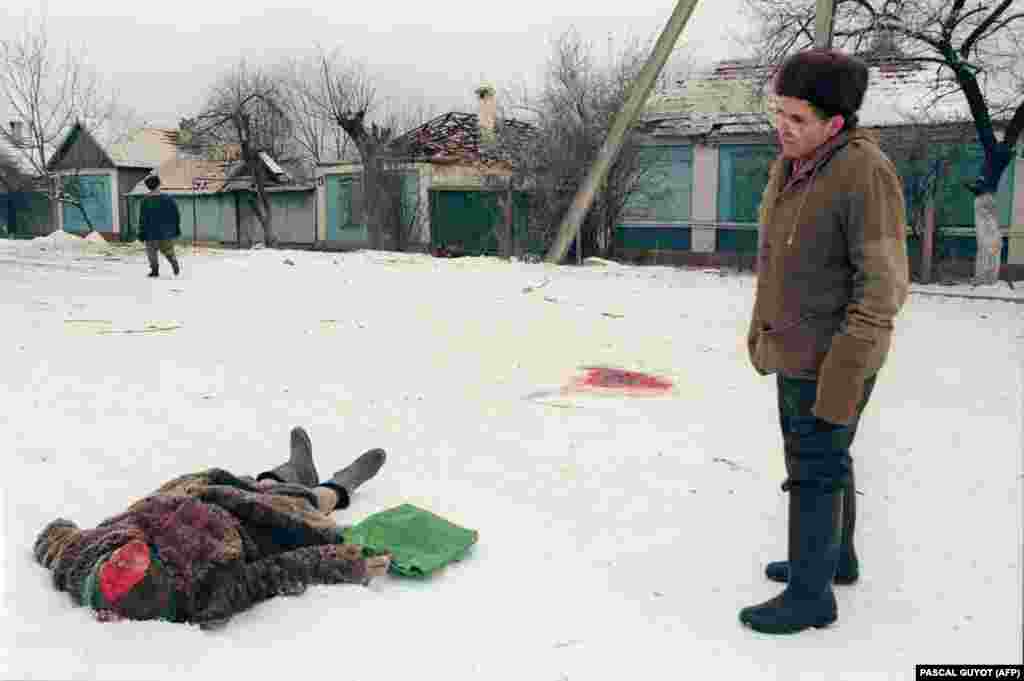 Ракетний обстріл &laquo;накрив&raquo; цю жінку на вулиці Грозного. Волонтери з місцевих жителів і навколишніх сіл після бомбардувань прочісують вулиці міста. Якщо встигають, то вивозять тіла до наступного бомбардування або ховають неподалік. 24 січня 1995 року