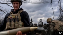 Військовослужбовці бригади НГУ «Хартія» готують гаубицю M101 до обстрілу російських позицій у Харківській області, 12 березня 2025 року