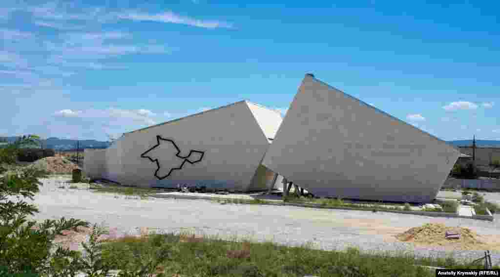 Главный объект комплекса – музей, который очертаниями напоминает большой разлом в скале. На одной из стен железнодорожными рельсами выложен контур Крымского полуострова, а на другой виднеется почти сливающаяся со стелой надпись «Мемориальный комплекс «Путь возрождения народов Крыма»