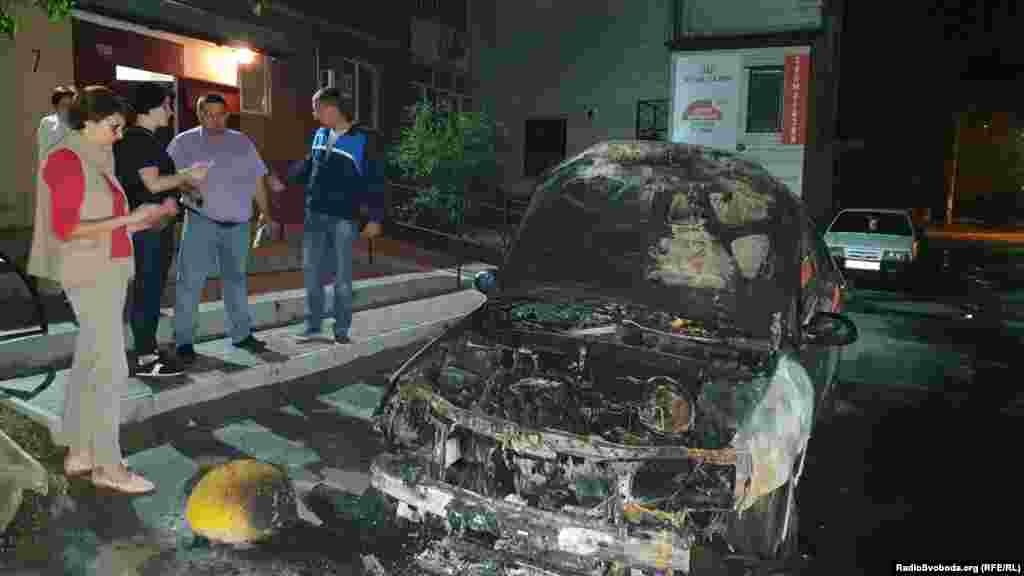 Інна Кузнецова біля спаленого автомобіля програми журналістських розслідувань «Схеми», серпень 2020 року  