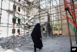Женщина проходит через руины здания, уничтоженного израильским авиаударом 13 июня. Тегеран, 19 июля 2025 года