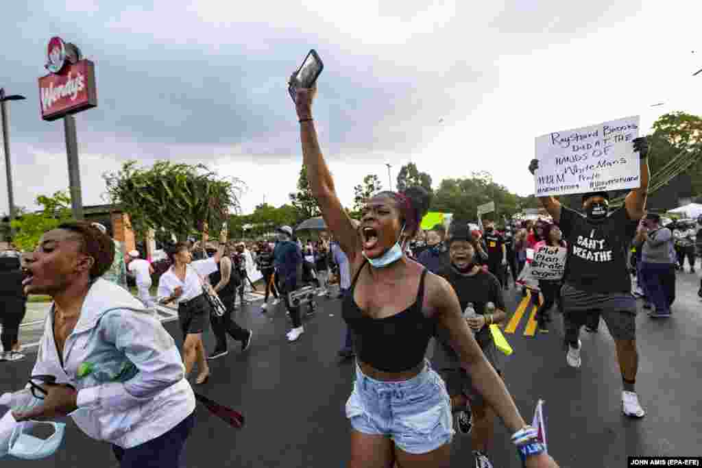 Протестувальники проходять повз зруйнований ресторан швидкого харчування Wendy’s. Атланта, штат Джорджія, США