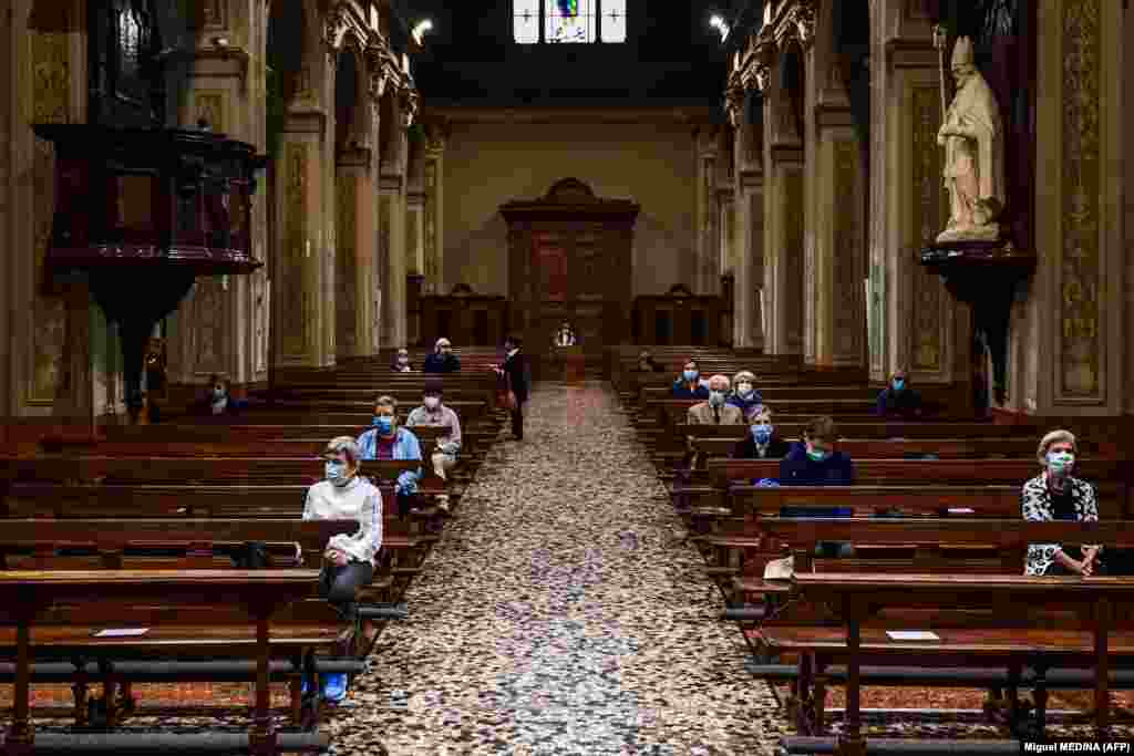 Віряни в масках на обличчі відвідують ранкову месу 20 травня 2020 року в церкві Сан-Б’яджо-е-Санта-Марія-Іммаколата в Кодоньйо, одному з містечок на південний схід від Мілану, що опинилося в епіцентрі коронавірусної епідемії в лютому. Зараз Італія послаблює карантинні заходи, спрямовані на стримування поширення інфекції COVID-19, спричиненої новим коронавірусом