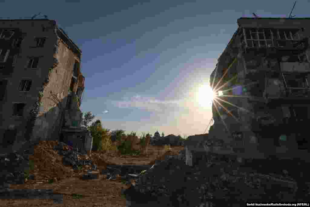 9 березня 2022 року російські військові завдали авіаудару по житловому будинку №2 по вулиці Першотравнева. В результаті загинуло щонайменше 44 людини, вересень 2022 року / Праворуч: початок жовтня 2024-го Першотравневу після деокупації міста перейменували на вулицю Пам'яті