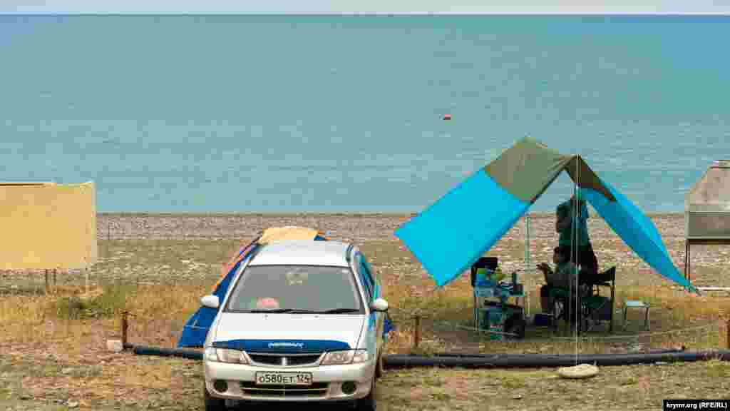 На автокемпинге у моря всего одна машина туристов. Судя по номерному знаку региона, они приехали в Рыбачку издалека – из Красноярского края соседней России