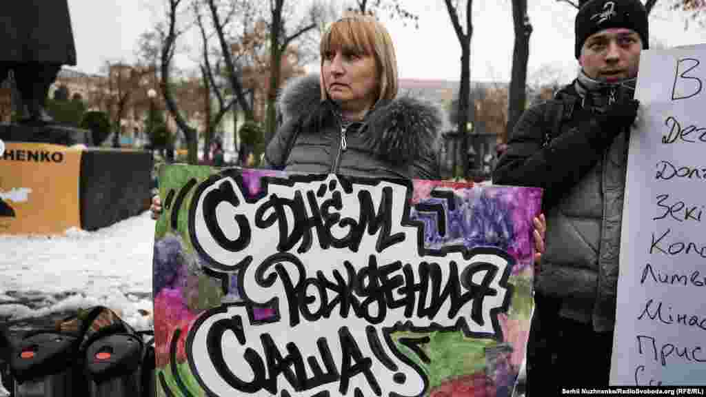 Мама Олександра Лариса Кольченко тримає плакат «З днем народження, Сашо»