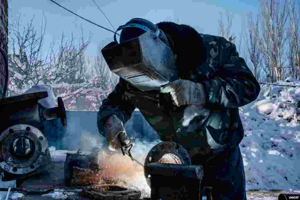 Загалом із початку конфлікту в Україні понад 30 працівників об’єктів системи водопостачання були вбиті або зазнали поранень. Лише у 2018 році на сході України було зафіксовано 89 нападів на об’єкти системи водопостачання. Ще 19 таких випадків було зафіксовано вже за перші три місяці 2019 року. На фото 59-річний Анатолій Сотников, працівник компанії «Вода Донбасу», зварює шматки сталі, щоб можна було використати стару трубу для ремонту пошкодженої ділянки водопроводу.