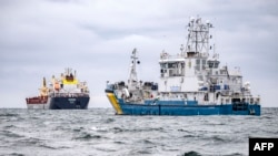 O navă a Gărzii de Coastă Suedeze (dreapta) și vasul sub pavilion maltez, Vezhen, suspectat de sabotarea unui cablu de fibră optică în Marea Baltică, la sfârșitul lunii ianuarie 2025. Vezhen a fost ancorat pentru cercetări în largul orașului suedez Karlskrona.