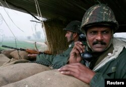 Солдати індійських прикордонних сил спостерігають за подіями навколо із бункера поблизу огородженого кордону з Пакистаном