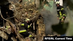 Echipele de salvare caută printre dărâmăturile unui bloc de apartamente din Kiev, după un atac rus.