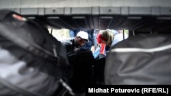 Izbjeglice pakuju stvari u autobus u Opatovcu, oktobar 2015