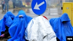 Мигранты в дождевиках на хорватско-словенской границе