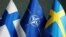 The Finnish (left) and Swedish (right) flags shown with the NATO symbol (center)