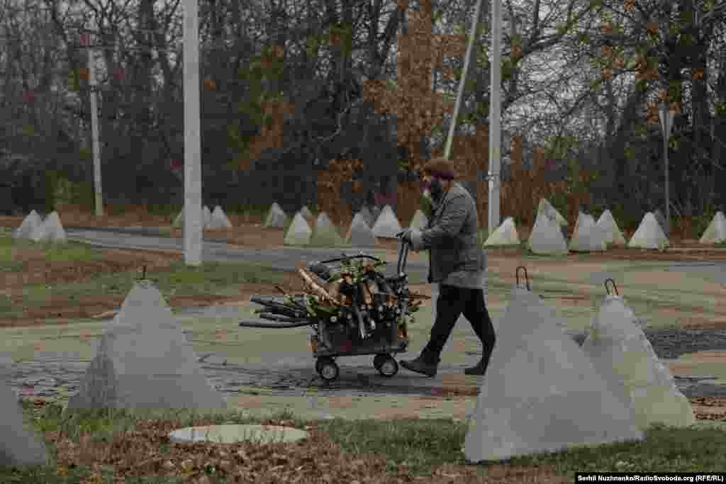 Чоловік везе на тачці дрова для опалення взимку. За ним дорога, яка веде на село Шевченко, за яке зараз йдуть бої. Звідси до лінії фронту менше ніж 5 км. Дехто з цивільних у розмові з нами розповідає про знайомих, які повертаються у Покровськ, причини різні: закінчились кошти на оренду житла, не знайшли роботу, не змогли звикнути до місця. Багато хто говорить, що держава не допомагає, а вся допомога – це виплата при офіційній евакуації – близько 11 тисяч гривень, якщо люди виїжджають самі, вони не можуть розраховувати навіть на ці кошти 