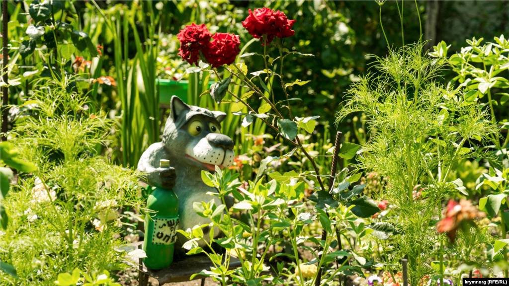 Приусадебный дизайн в селе Соколиное Бахчисарайского района. Хозяин усадьбы под кустом розы разместил фигуру волка – персонажа популярного советского рисованного мультипликационного фильма «Жил-был пес»