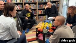 Bjeloruska opoziciona liderka Svjetlana Tihanovskaja (naprijed lijevo) sa oslobođenim zatvorenicima, uključujući bivšeg novinara RSE Ihara Karneija (treći s lijeva), u Litvaniji.