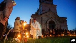 Sveštenik Serhij Žezul blagosilja vaskršnje korpe ispred crkve srušene u borbama između ruskih i ukrajinskih snaga u selu Lukašivka, Ukrajina, 20. aprila.