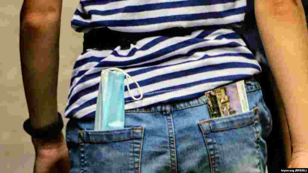 Одноразова медична маска в кишені у дівчини. Зустріти відвідувачів в індивідуальних засобах захисту – велика рідкість, попри дію в Криму маскового режиму