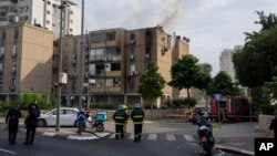 Дим піднімається над будівлею, ураженою ракетою, випущеною з Гази, у Тель-Авіві, Ізраїль, жовтень 2023 року