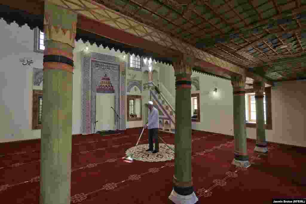 Чоловік пилососить килим у мечеті в Башчаршії