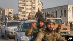 Sirijski opozicioni borci voze se ulicama Hame, Sirija, u petak, 6. decembra 2024.