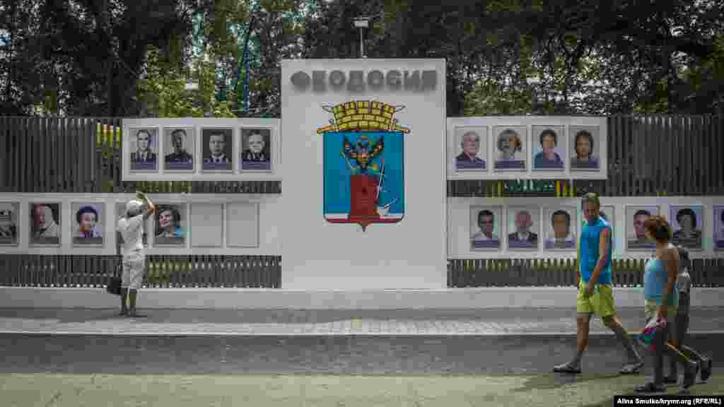 Мужчина рассматривает «Доску почета», которую открыли накануне в Феодосии 