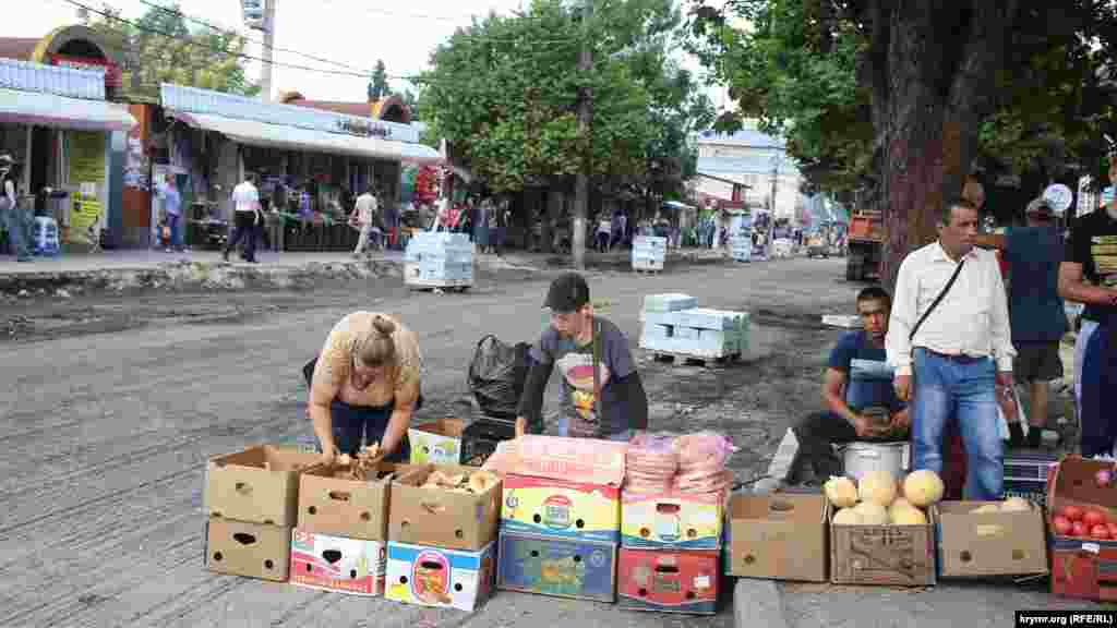 Еще не успели закатать новый асфальт, а новые торговцы уже тихо занимают себе новые места, 16 июля 2015 года