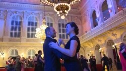 Продавці журналу і гості події танцюють під акомпанемент оркестру