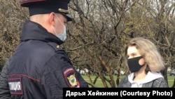 Сотрудник полиции на встрече с активистами предупреждает Дарью Хейкинен о недопустимости мероприятия