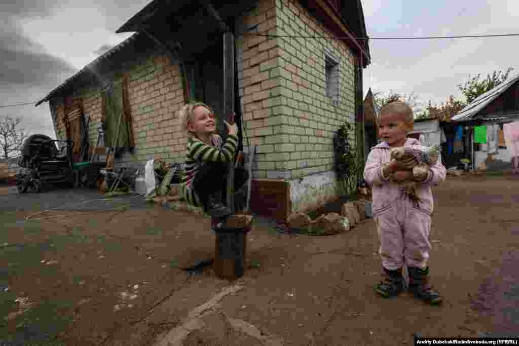Семирічна Діана і трирічний Герман граються на подвір’ї свого будинку, який розташований неподалік передової лінії оборони української армії в селищі Зайцеве, що під окупованою Горлівкою, 22 жовтня 2019 року