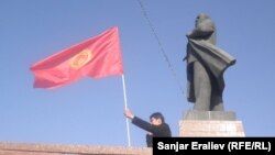 Čovek maše kirigistanskom zastavom pored statute Lenjina u gradu Oš, 4. septembra 2012. Gradske vlasti su u junu uklonile tu statuu.