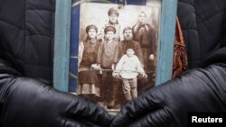 Жінка тримає фотографію своїх рідних, які померли від голоду, влаштованого сталінським радянським режимом у 1932-33 роках