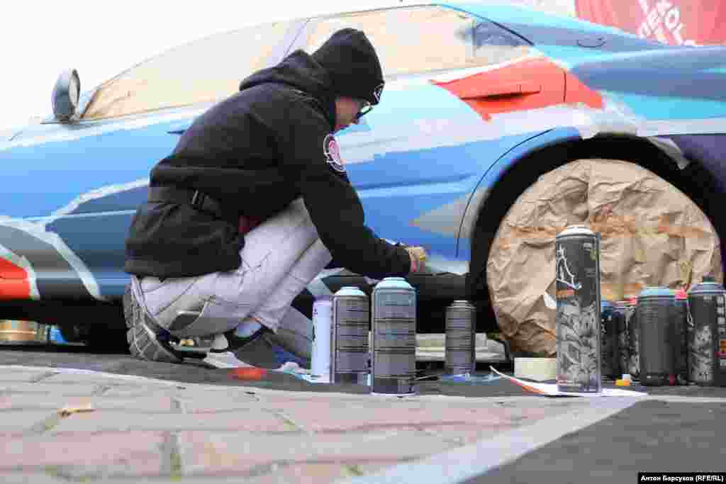 Перед тем, как начать наносить краску, кузов машины нужно "заматировать". Так мастера называют процедуру снятия верхнего глянцевого слоя заводской краски. Если этого не сделать, рисунок начнет сходить примерно через месяц. После этой процедуры долговечность нового красочного слоя практически соспоставима с оригинальной окраской