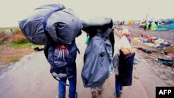 Семья мигрантов на границе Сербии и Венгрии у города Роске, 10 сентября 2015 года