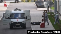 Сотрудники скорой помощи у многопрофильного медицинского центра, куда госпитализируют пациентов с подозрением на коронавирус COVID-19, май 2020 года