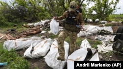 Украинский военнослужащий во время эксгумации убитых военных России на их прежних позициях вблизи села Мала Рогань в окрестностях Харькова