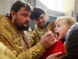 Дівчинка під час причастя у Спасо-Преображенському храмі в Києві, 28 жовтня 2018 року